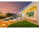 Expansive backyard featuring a private pool, covered patio, green space and tasteful landscaping with string lights at 1312 W Bartlett Way, Chandler, AZ 85248