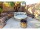 Cozy backyard lounge area with comfortable seating around a modern fire pit, surrounded by lush desert landscaping at 1312 W Bartlett Way, Chandler, AZ 85248