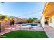 A backyard oasis with a sparkling pool, manicured lawn, elegant patio furniture, and ambient string lights at 1312 W Bartlett Way, Chandler, AZ 85248
