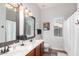 Bathroom with dual sinks, wood cabinets, framed mirrors, and a walk-in shower at 1312 W Bartlett Way, Chandler, AZ 85248