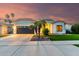 Beautiful one story home with a well-manicured lawn, two palm trees and a two car garage at sunset at 1312 W Bartlett Way, Chandler, AZ 85248