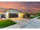 Beautiful one story home with a well-manicured lawn and a two car garage and a long driveway at sunset at 1312 W Bartlett Way, Chandler, AZ 85248