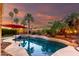 Backyard pool featuring lights, palm trees, and colorful sky at 1312 W Bartlett Way, Chandler, AZ 85248