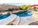 Relaxing backyard pool features stone steps leading into the pool and spa with natural rock accents at 1312 W Bartlett Way, Chandler, AZ 85248