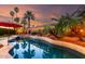 Backyard pool featuring lights, palm trees, and colorful sky at 1312 W Bartlett Way, Chandler, AZ 85248