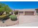 Beige house featuring a three-car garage, desert landscaping, rock detail and a charming desert tree in the front yard at 14806 E Lookout Ledge --, Fountain Hills, AZ 85268