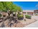 Tan house featuring a large front yard with desert landscaping, rock detail and a charming desert tree for shade at 14806 E Lookout Ledge --, Fountain Hills, AZ 85268