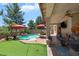 Inviting backyard featuring a pool, a putting green, outdoor seating and mature trees at 17541 W Statler Dr, Surprise, AZ 85388