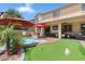 Relaxing backyard with a pool, putting green, covered patio, and well-maintained landscaping at 17541 W Statler Dr, Surprise, AZ 85388