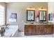 Luxury main bathroom features dual sinks, granite counters, a soaking tub, and stylish fixtures at 17541 W Statler Dr, Surprise, AZ 85388