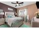Nicely appointed bedroom with a stylish bed, turquoise accents, and a ceiling fan at 17541 W Statler Dr, Surprise, AZ 85388