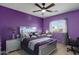 A purple-themed bedroom with a mirrored bed frame, a vanity, and modern decor at 17541 W Statler Dr, Surprise, AZ 85388