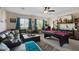 Spacious living room features a comfortable sectional, a pool table, and a large television at 17541 W Statler Dr, Surprise, AZ 85388