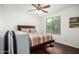 Comfortable bedroom featuring a ceiling fan, wood floors and a large window allowing natural light into the space at 17753 W Columbine Dr, Surprise, AZ 85388