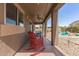 Comfortable covered patio featuring a ceiling fan and wicker rocking chair, perfect for outdoor relaxation at 17753 W Columbine Dr, Surprise, AZ 85388
