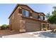 Two-story home shows stone accents, a spacious driveway, and a neatly landscaped yard at 17753 W Columbine Dr, Surprise, AZ 85388