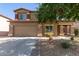 Charming two-story home with a large driveway, desert landscaping, and stone accents on the facade at 17753 W Columbine Dr, Surprise, AZ 85388