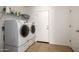 Functional laundry room with modern washer and dryer, white cabinets and shelving for ample storage at 17753 W Columbine Dr, Surprise, AZ 85388