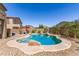 Beautiful in-ground pool with rock features and a Baja shelf, set in a private backyard oasis at 17753 W Columbine Dr, Surprise, AZ 85388