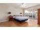 Bedroom with ceiling fan and large sliding glass doors open to patio, laminate wood floors, and neutral paint at 1953 E Laguna Dr, Tempe, AZ 85282