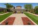Landscaped backyard featuring artificial turf, brick pavers, mulch beds and mature trees, ideal for relaxation at 198 E Patton Ave, Coolidge, AZ 85128