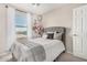 Comfortable bedroom with a tufted headboard, soft bedding, and bright natural light from the window at 198 E Patton Ave, Coolidge, AZ 85128
