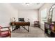 Bright home office featuring hardwood floors, sleek modern desk, and large window providing natural light at 198 E Patton Ave, Coolidge, AZ 85128