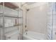 Tiled bathtub and shower combo featuring an adjustable showerhead and storage shelving at 2031 W Gila Ln, Chandler, AZ 85224