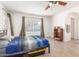 Comfortable bedroom features a ceiling fan, wood-look tile flooring and bright natural light at 2031 W Gila Ln, Chandler, AZ 85224