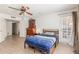 Bright bedroom with wood-look tile flooring, ceiling fan and a private outdoor access at 2031 W Gila Ln, Chandler, AZ 85224