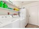 Laundry room featuring washing machine, dryer, white appliances, and shelving at 2031 W Gila Ln, Chandler, AZ 85224
