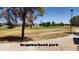 Expansive neighborhood park with lush green grass, mature trees and open space at 2031 W Gila Ln, Chandler, AZ 85224