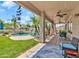 Inviting backyard with in-ground pool, patio, lounge chairs, ceiling fans, and lush tropical landscaping at 21167 E Aspen Valley Dr, Queen Creek, AZ 85142