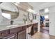 Elegant bathroom with double vanity, granite counters, stylish mirrors, and a walk-in closet at 21167 E Aspen Valley Dr, Queen Creek, AZ 85142
