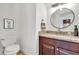 Bathroom features granite counters, a dark wood vanity and round mirror with decorative fixtures at 21167 E Aspen Valley Dr, Queen Creek, AZ 85142