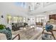 Bright and airy living room boasting a soaring ceiling, stylish furniture, and seamless flow to the kitchen and dining area at 21167 E Aspen Valley Dr, Queen Creek, AZ 85142
