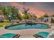In-ground pool with stone waterfall, desert landscaping, lounge chairs, and outdoor umbrella at 21167 E Aspen Valley Dr, Queen Creek, AZ 85142