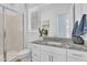 Bright bathroom with granite counters, white cabinets, a decorative plant, and a glass shower at 21934 E Lords Ct, Queen Creek, AZ 85142