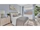 Cozy bedroom with soft blue walls, large window, and neutral toned furniture at 21934 E Lords Ct, Queen Creek, AZ 85142