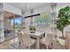Dining area with a modern light fixture, large windows, and sliding door access to outdoor seating and greenery at 21934 E Lords Ct, Queen Creek, AZ 85142