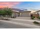 Charming home featuring a three car garage, a brick driveway, and desert landscaping in front at 21934 E Lords Ct, Queen Creek, AZ 85142