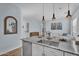 Open-concept living space with kitchen island, stainless steel appliances, and wood floors at 21934 E Lords Ct, Queen Creek, AZ 85142