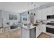 Open concept living space with kitchen island, white sofa, wood floors, and stainless steel appliances at 21934 E Lords Ct, Queen Creek, AZ 85142