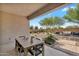 Inviting covered patio with outdoor dining and a well-manicured backyard with desert landscaping at 21934 E Lords Ct, Queen Creek, AZ 85142