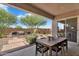 Inviting covered patio with outdoor dining and a well-manicured backyard with desert landscaping at 21934 E Lords Ct, Queen Creek, AZ 85142
