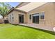 Large artificial turf backyard with sliding glass doors to the house at 21973 N 102Nd Ln # 411, Peoria, AZ 85383