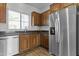 Functional kitchen with stainless steel appliances, wooden cabinetry, and a window view at 21973 N 102Nd Ln # 411, Peoria, AZ 85383