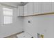 Laundry room with white cabinets, tile flooring, and a utility sink at 21973 N 102Nd Ln # 411, Peoria, AZ 85383