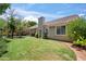 The spacious backyard features a lush lawn, a covered patio, and mature trees, perfect for outdoor enjoyment and relaxation at 2243 E Cortez Dr, Gilbert, AZ 85234