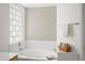 Bright bathroom featuring a tub with jets and a glass block window at 2243 E Cortez Dr, Gilbert, AZ 85234